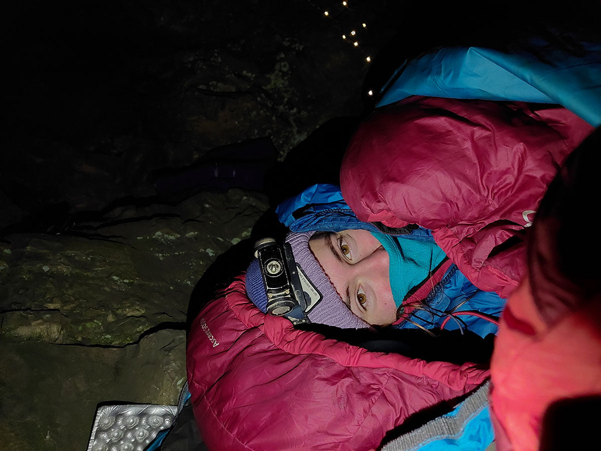 The author wrapped up in lots of layers beneath a rock, taken by Todd Rye