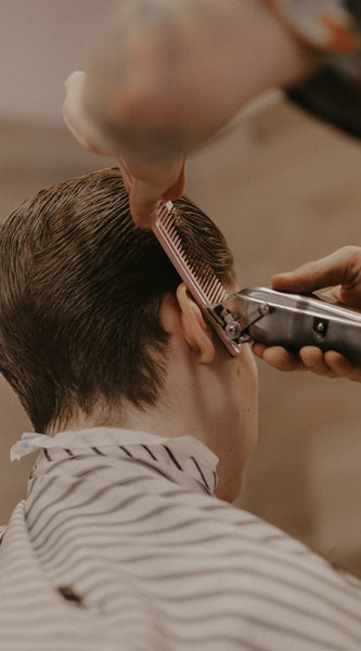 Barber cutting man's hair