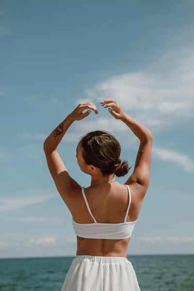 Girl with hydrated glowing skin on the beach, hydrating body oils