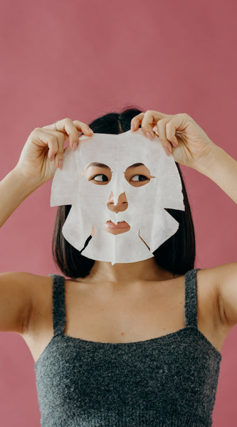 Woman removing sheet mask from face