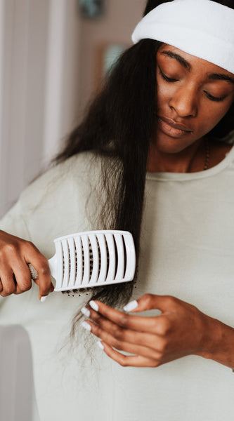 Woman with long black hair combing her hair