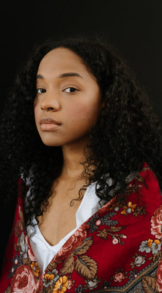 Woman with long curly hair and acne