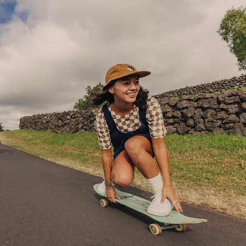 Girl on skeatboard sliding down a hill wearing all-natural clothing