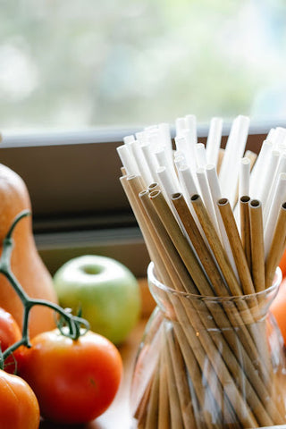 A bunch of bamboo straws inside a glass jar