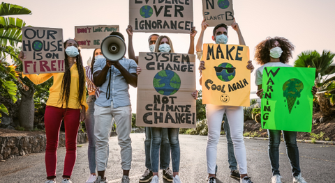 people standing and holding signs to protest climate change