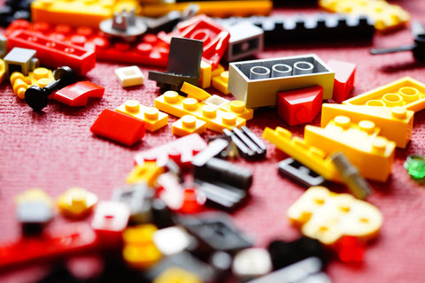 various sizes and colours of Lego pieces laying on the ground 