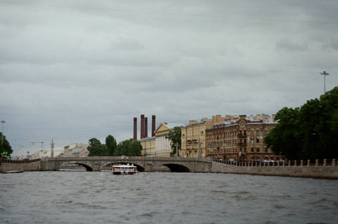 ferry boat travelling on water way under bridge 