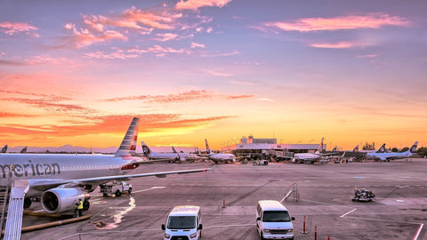 airplane sunset with vehicles on airport runway