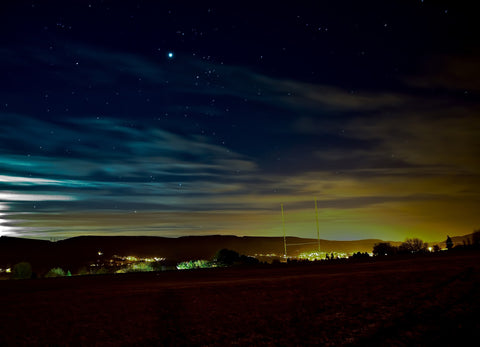light pollution from city across night sky 