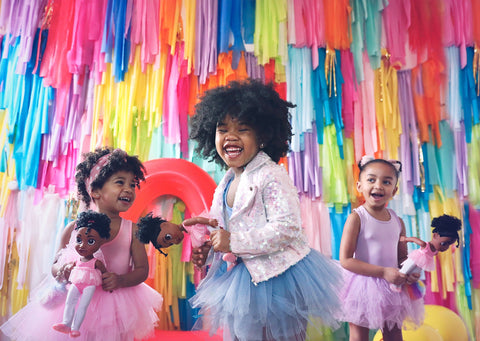 3 black ballerinas holding black ballerina doll