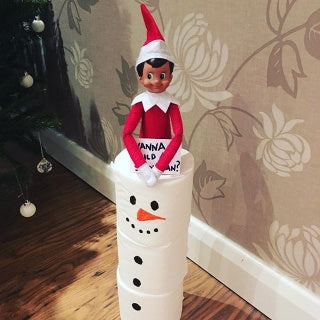 Elf building snowman
