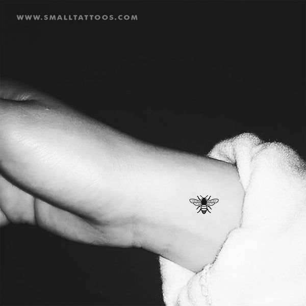 Micro ladybug tattoo located on the tricep