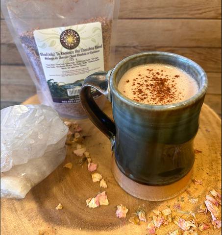 Crystal, hot chocolate mix and a cup of hot chocolate on a wooden board with rose petals