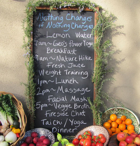A blackboard with chalk written words displaying a daily retreat schedule.