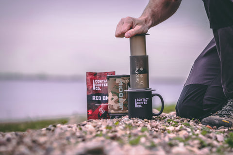 man using aeropress outside