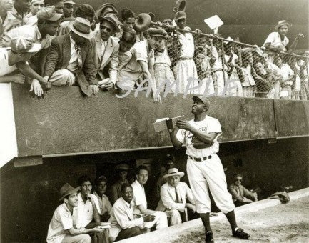 Jackie Robinson signs autographs at the stadium while in Cuba during Spring Training.