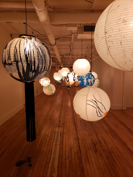 More individually painted lanterns hanging in a gallery