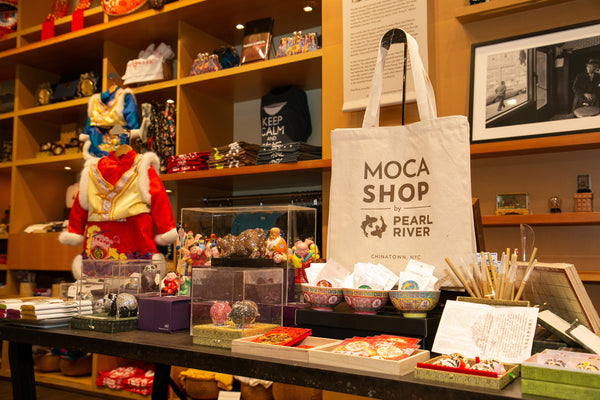 MOCA Shop by Pearl River tote bag on a table with other items