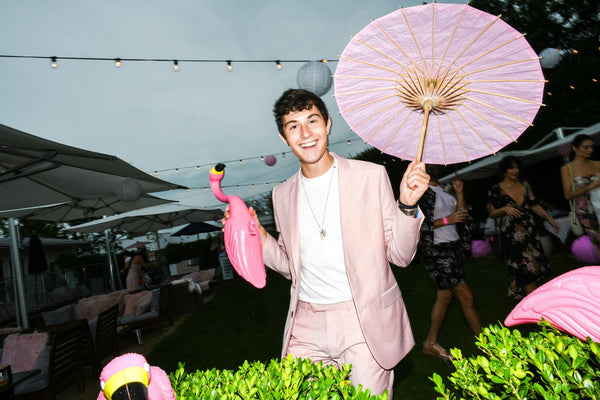 Young man posing with pink parasol