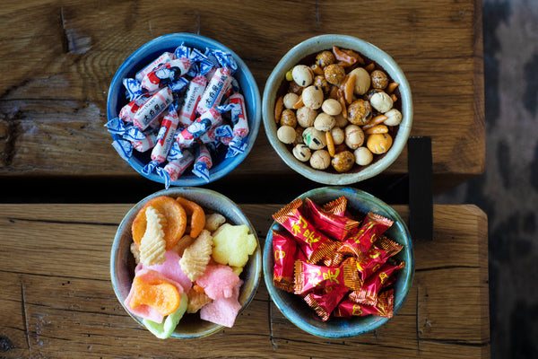 Bowls of White Rabbit candy, Asian mixed nuts, shrimp chips, and lucky candy