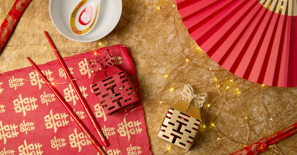 Beautiful arrangement of double happiness wrapping paper, chopsticks, candy boxes, fan, and bowl with spoon