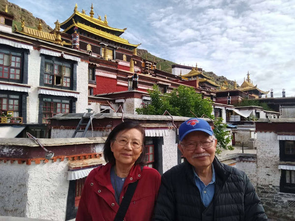 Pearl River Mart founders mr. and mrs. chen in front of a temple in Tibet