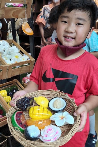 Boy holding basket of Tanida soaps in Thailand