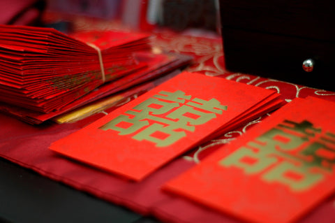 Stacks of hong bao, or red envelopes, with double happiness characters
