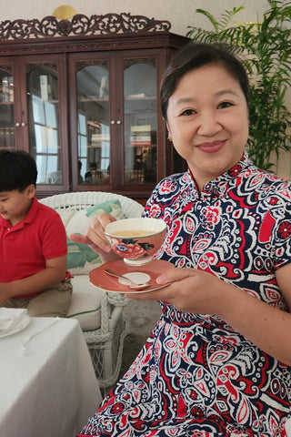 Joanne Kwong in pretty dress drinking high tea