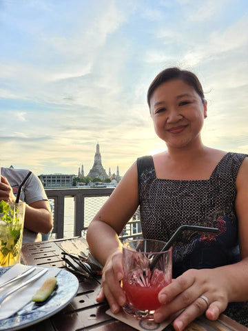 Pearl River president Joanne Kwong in batik dress with drink in Thailand