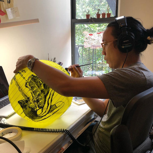 John Lee painting sneakers onto a yellow lantern