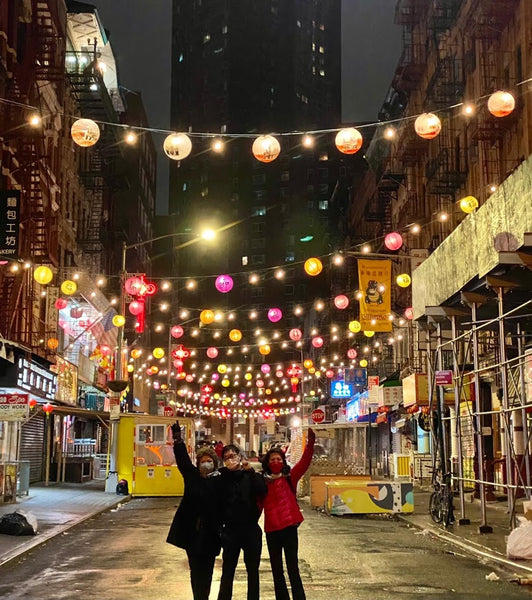 Chung Seto, Patrick Mock, and Jenny Lam Low posing in front of lanterns on Bayard Street.