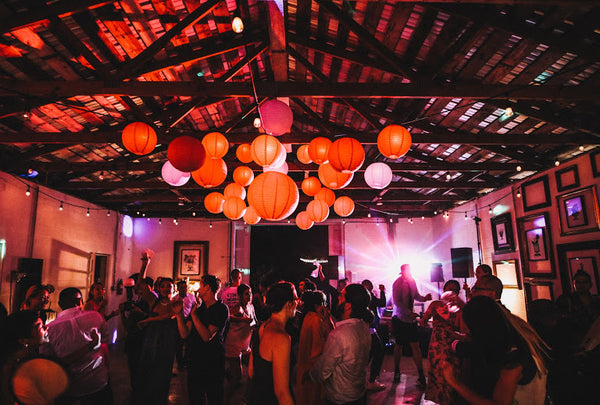 Guests dance under colorful lanterns