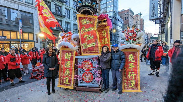 Joanne Kwong, Mr. and Mrs. Chen, lion dancers with Lunar New Year banners on Broadway in Soho