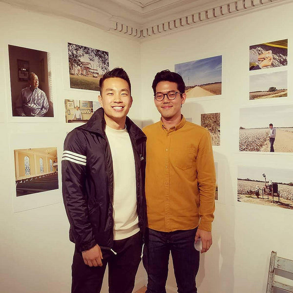 Photographers Andrew Kung and Emanuel Hahn posing in front of their photos