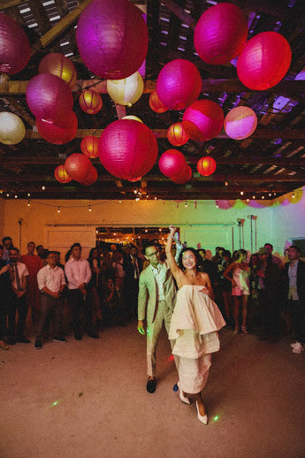 The bride and groom dance under lanterns