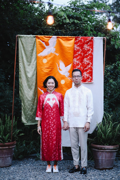 Vicki Ho and husband Todd pose in front of beautiful brocade fabrics.