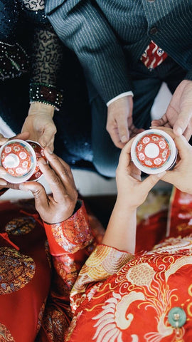 A bride and groom serve tea to the groom's parents