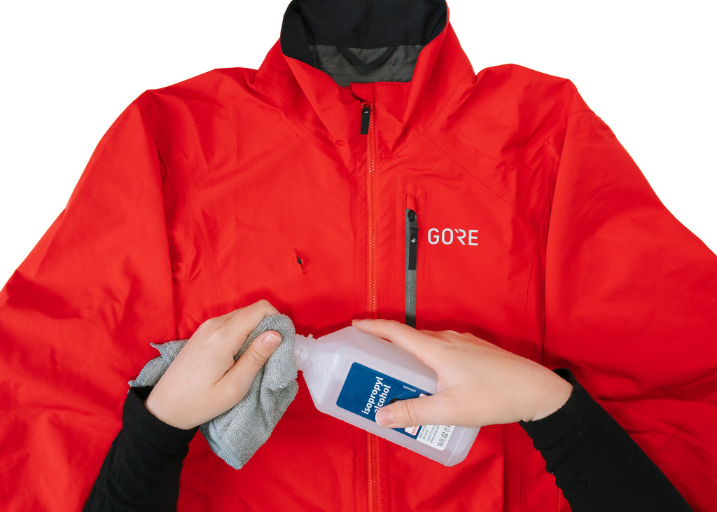 GEAR AID Tenacious Tape patch being applied to a GORE WEAR jacket