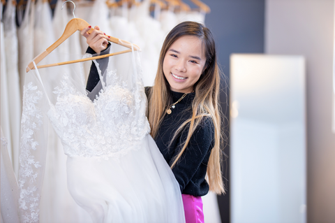 Eliza holding a white wedding dress