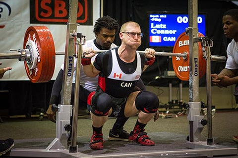 Powerlifter masculin accroupi en compétition