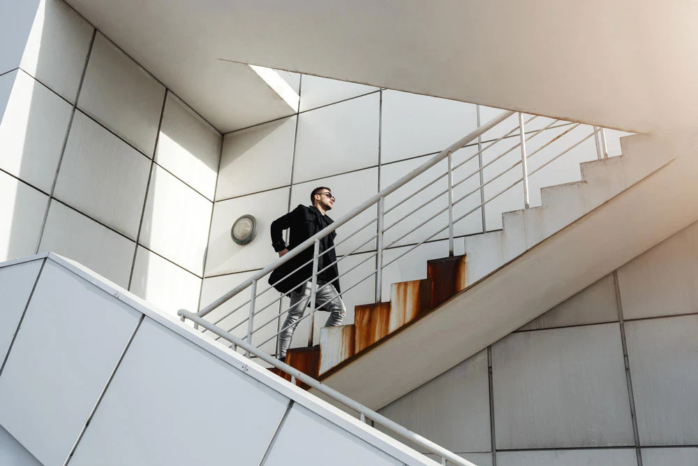 Stylish man in merino shorts walking up stairs