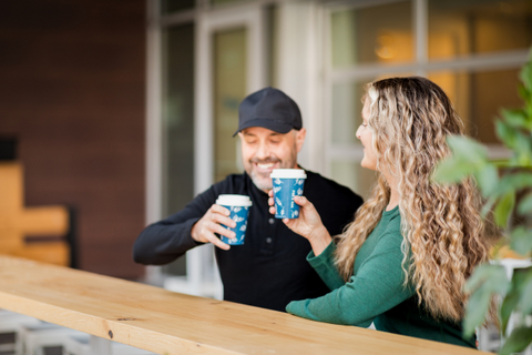 Man and woman drinking coffee outdoors