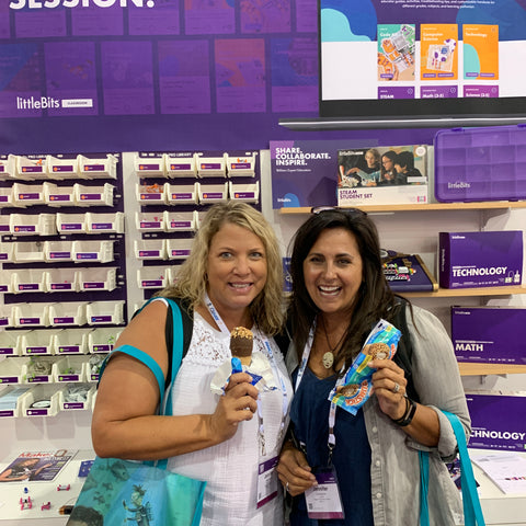 Two women in front of littleBits booth holding up ice cream treats to the camera.