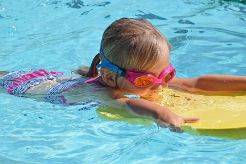 Girl swimming using a board