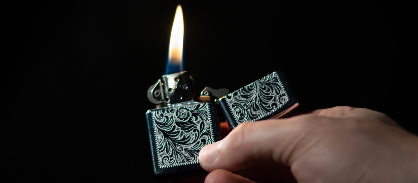 Black and silver pattern Zippo lighter in hand
