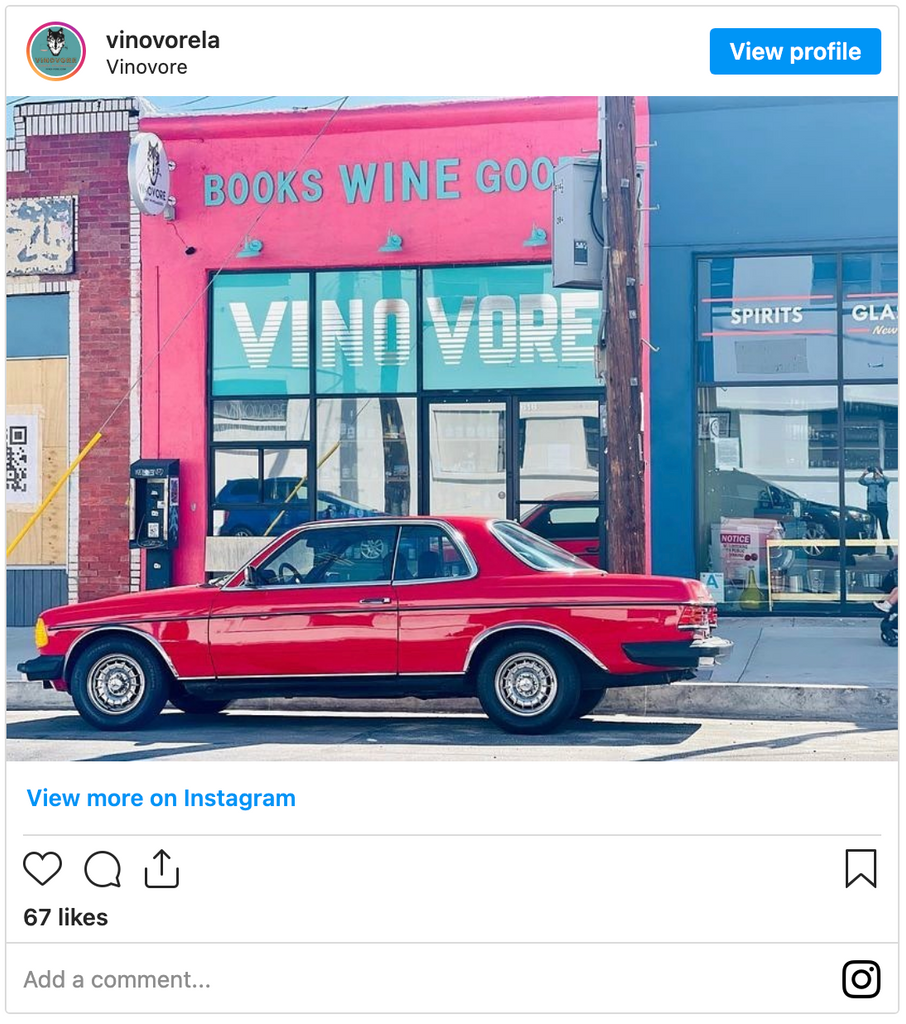 Exterior of Vinovore wine shop with a red vintage BMW parked in front