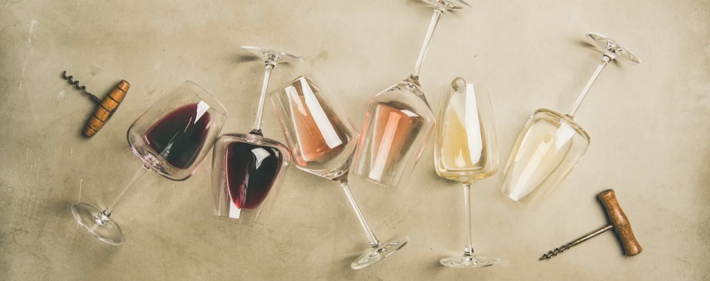 Wine glasses laying down, with various kinds of wine in them
