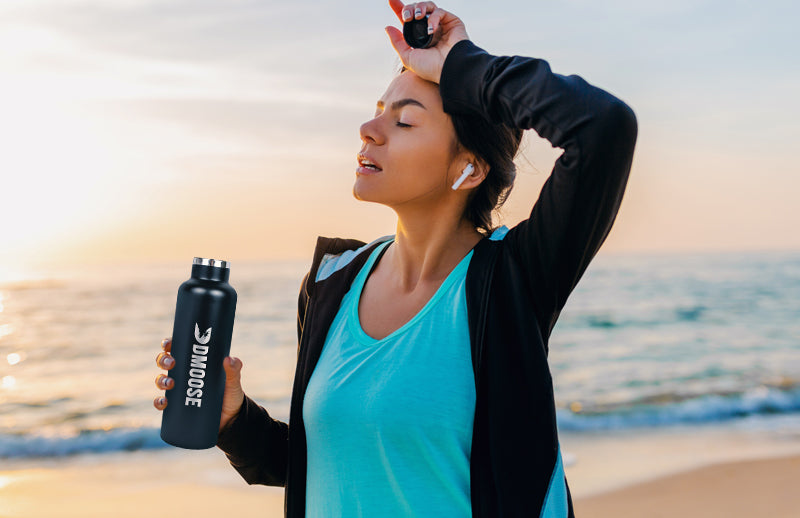 A woman using DMoose insulated water bottle to stay hydrated