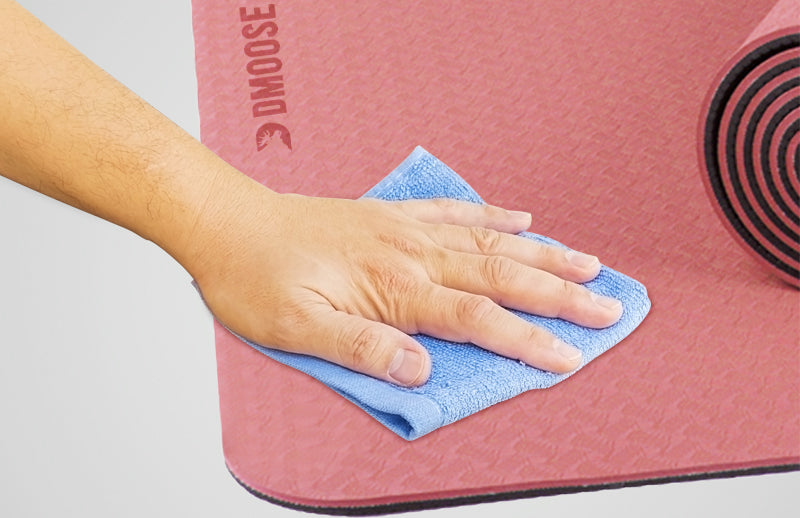 A hand cleaning DMoose yoga mat with cloth